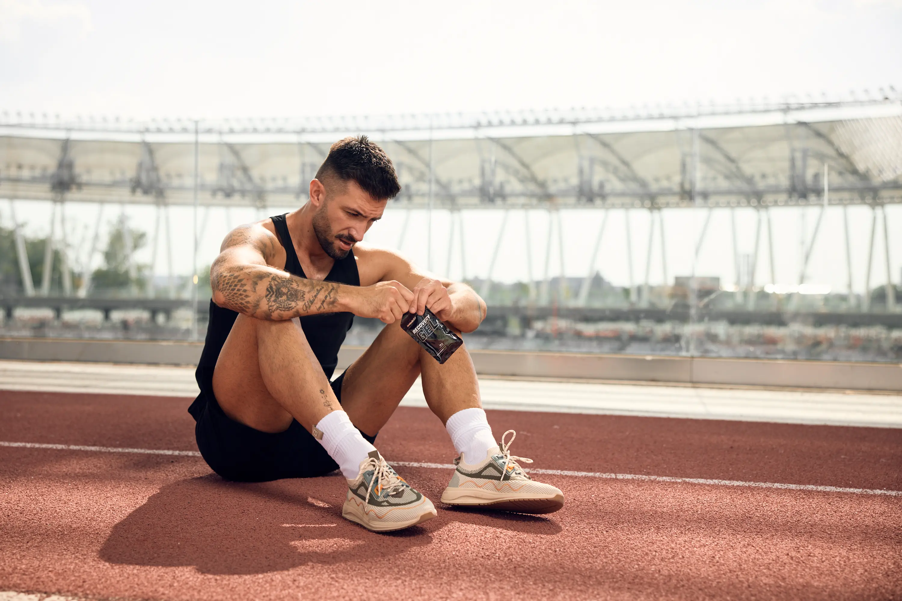 Runner sitting and takes supplement after running